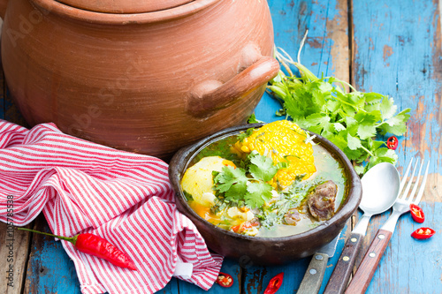 Latin american food. Cazuela - traditional chilean soup served in clay plate from pomaire photo