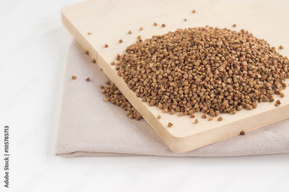 Pile of buckwheat seeds on the wooden board Pile of buckwheat seeds on the wooden board