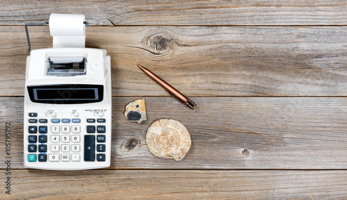 Vintage adding machine and stone fossils on rustic wooden boards