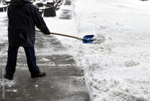 A man removes snow with shovel
