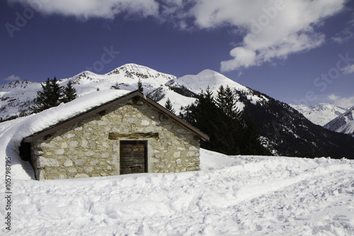 mountain panorama with hut covered in snow