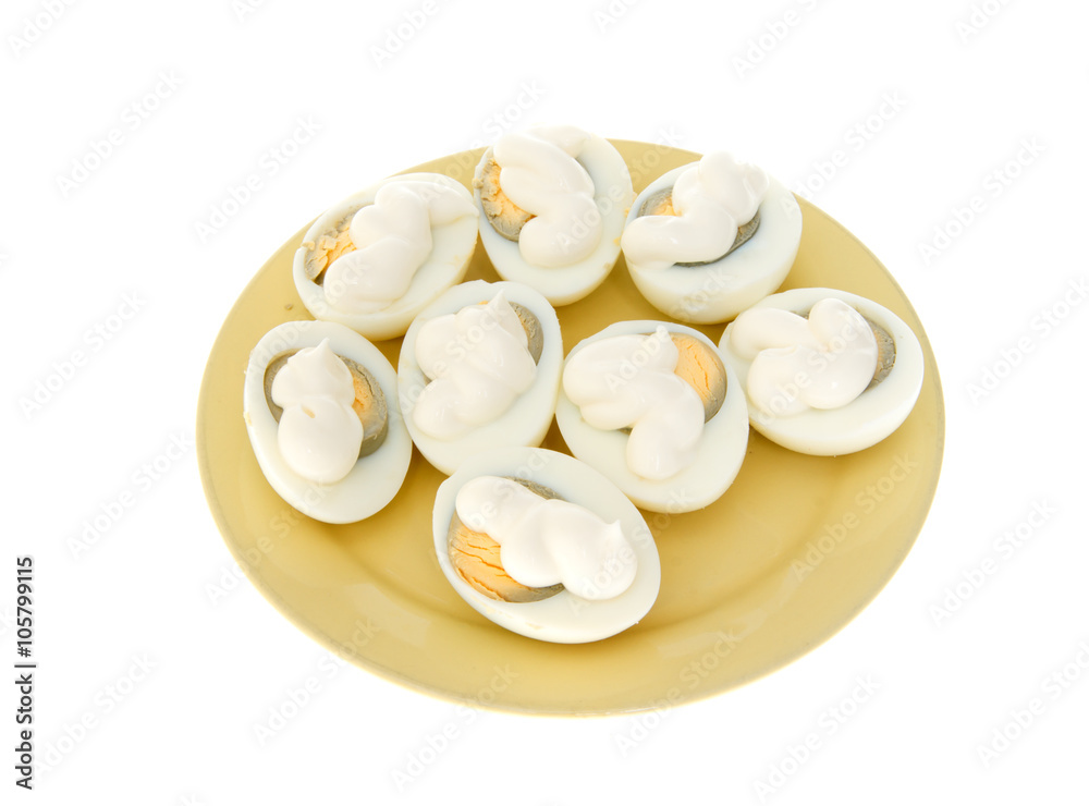 Eggs under mayonnaise on a yellow plate isolated Eggs under mayonnaise on a yellow plate isolated