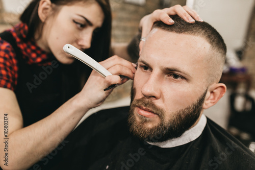 Bearded hipster client visiting barber shop 