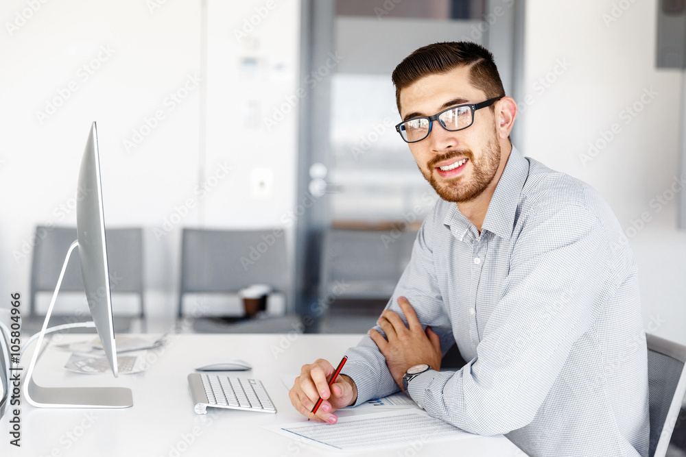 Male office worker sitting at desk Male office worker sitting at desk