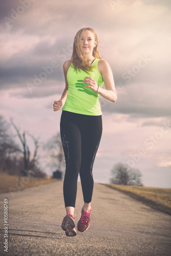 Fit young woman running at ...