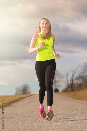 Fit young woman running at ...