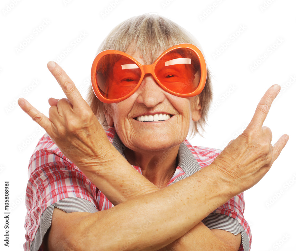 Senior woman wearing big sunglasses doing funky action isolated