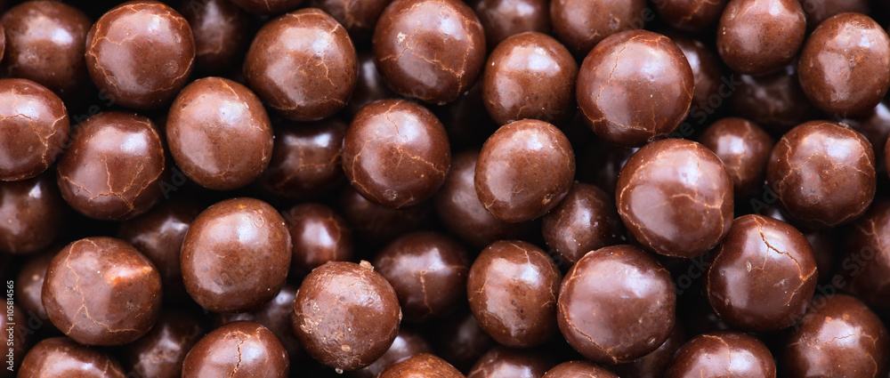 Brown chocolate dragee balls background, close up, top view, le Brown chocolate dragee balls background, close up, top view, le