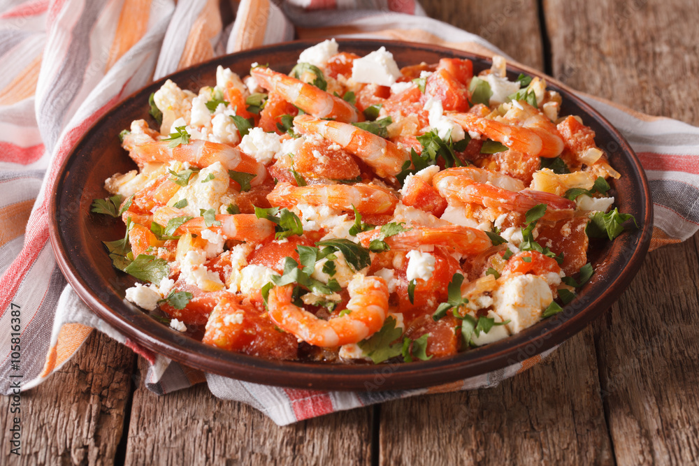 Shrimp with tomatoes and feta cheese on a plate close-up. horizontal
Shrimp with tomatoes and feta cheese on a plate close-up. horizontal