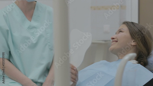 Smiling young woman receiving dental checkup. 