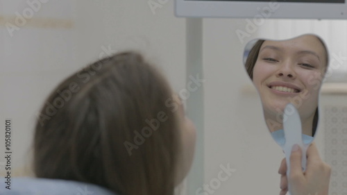 Smiling young woman receiving dental checkup. 