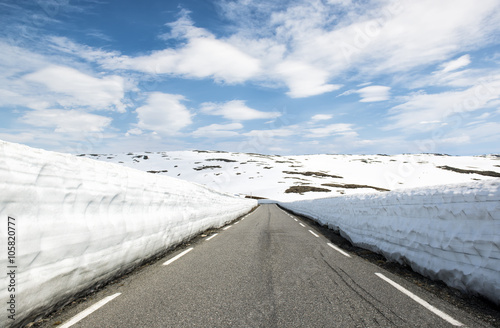 Asphalt road through the mountains with a lot of snow, summer Norway. National Tourist Route Aurlandsfjellet photo