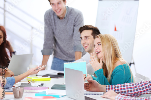 Happy young blonde woman sitting at the office meeting