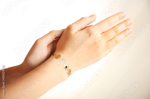 Golden flash tattoo on female wrist over white background