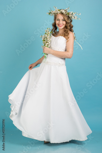Bride with wreath of flowers isolated on blue