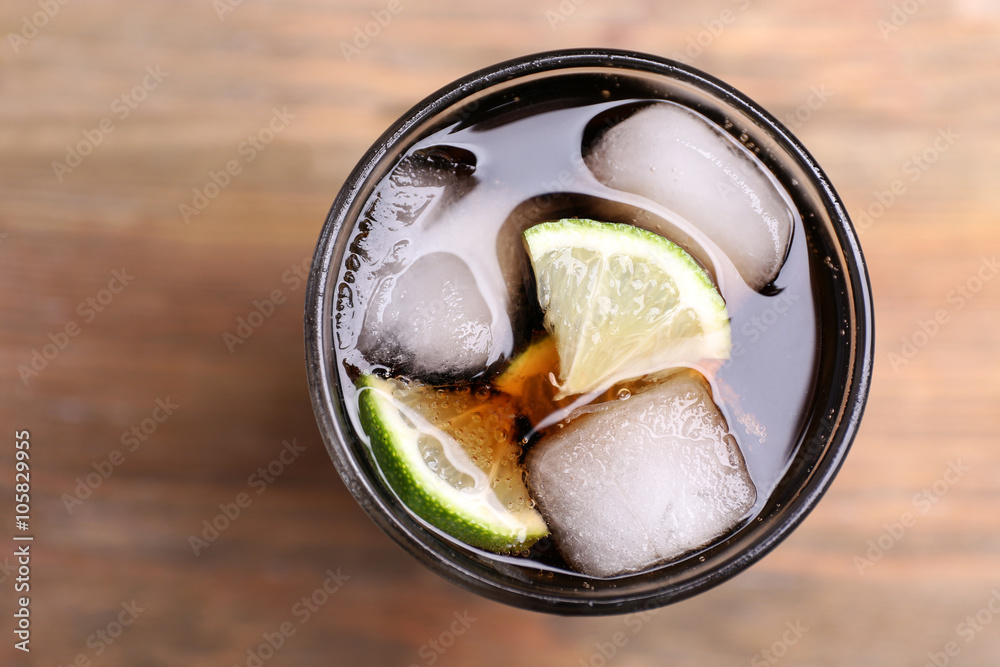 Cocktail with lime slices and ice blocks on wooden table, top view Cocktail with lime slices and ice blocks on wooden table, top view