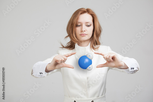 Young woman scientist with model of water molecule.