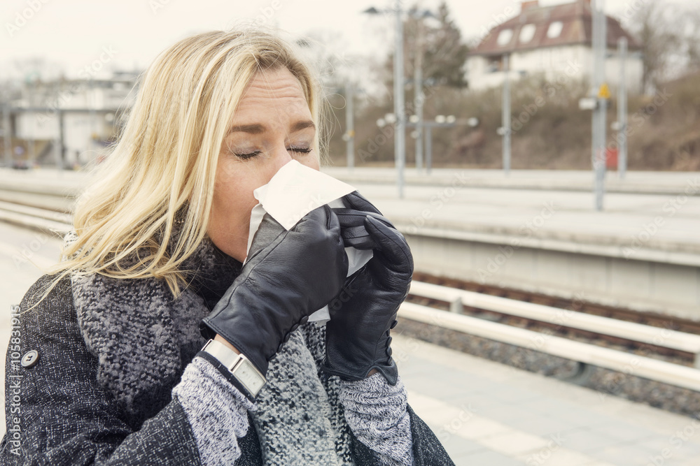 woman at train station having a cold