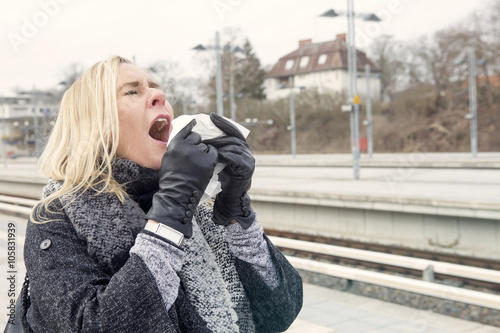 woman at train station having a cold