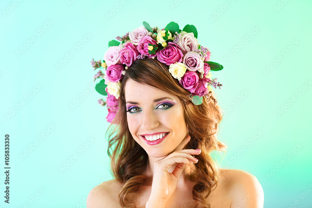 Beautiful young woman wearing floral headband on a green background Beautiful young woman wearing floral headband on a green background