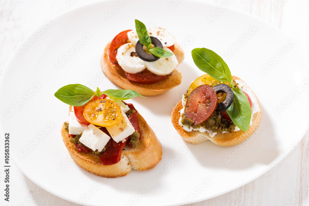 bruschettas with tomatoes and mozzarella on plate, top view bruschettas with tomatoes and mozzarella on plate, top view
