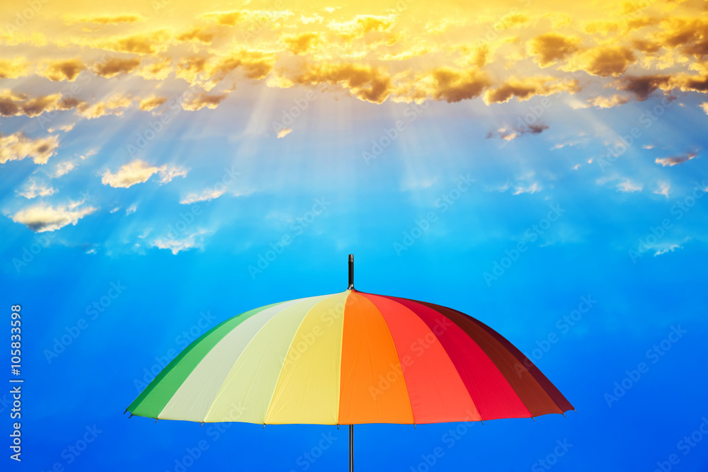 Rainbow umbrella against the sky