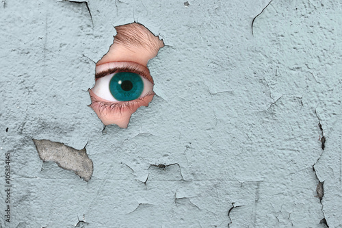 Tableau sur toile occhio che spia attraverso un buco nel muro
