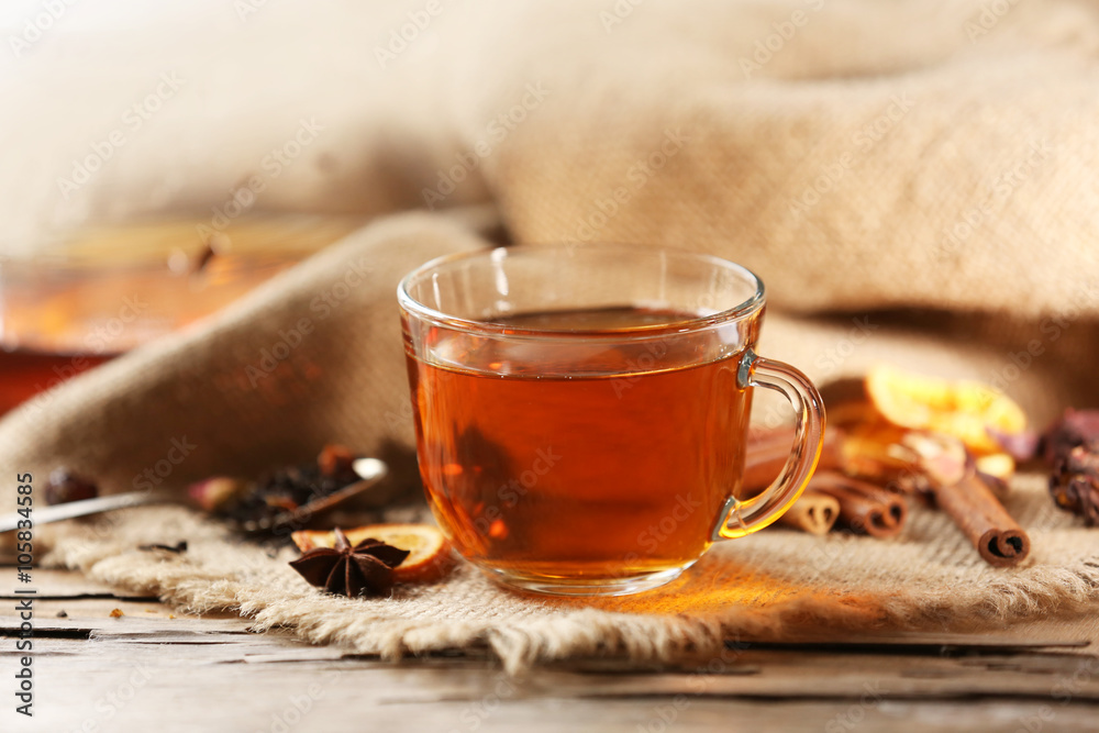 Glass cup of tea with spices on sackcloth background Glass cup of tea with spices on sackcloth background