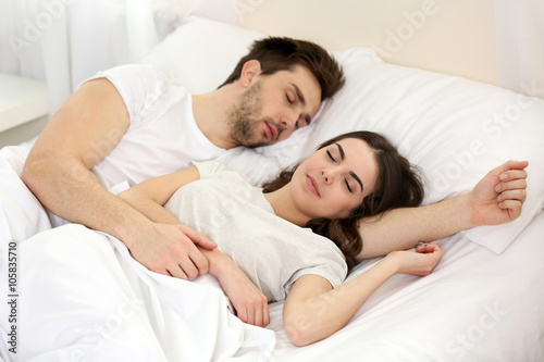 Young cute couple sleeping together in bed © Africa Studio