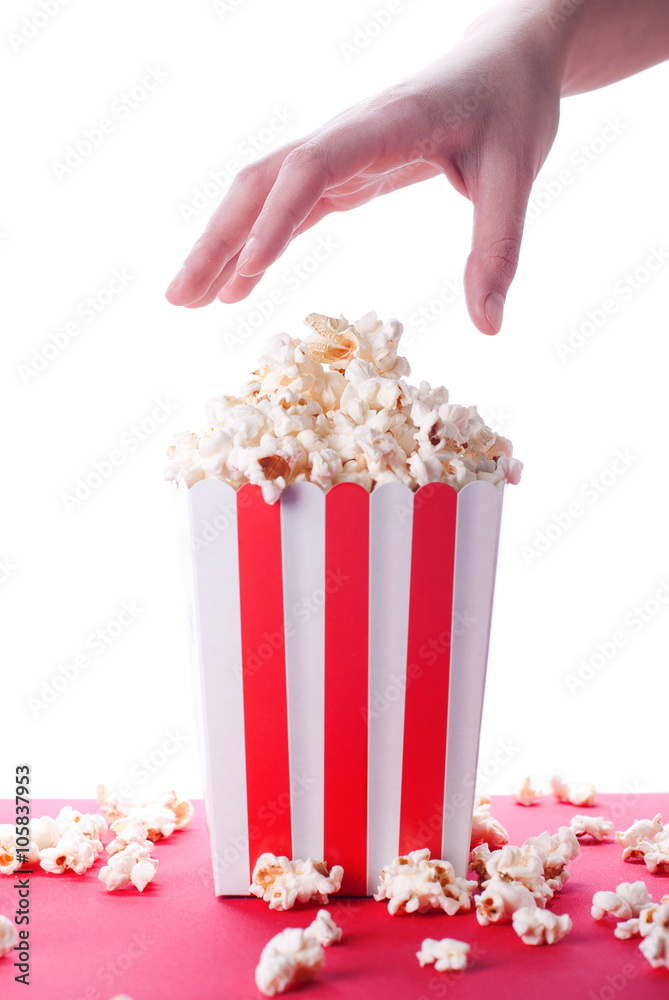 Fototapeta premium popcorn and hand on isolated background
