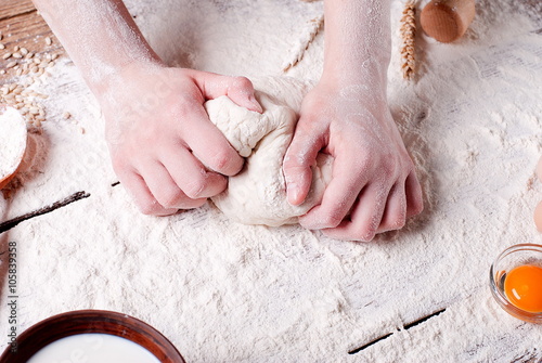 women's hands knead the dough