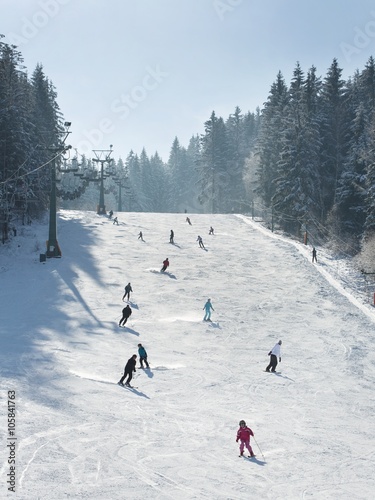 Skiers and snowboarders going down the slope