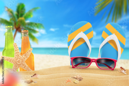 Fototapeta Naklejka Na Ścianę i Meble -  Sunglasses, juice and slippers on beach. Starfish and shells on sand. Beach and sea with palm in background.