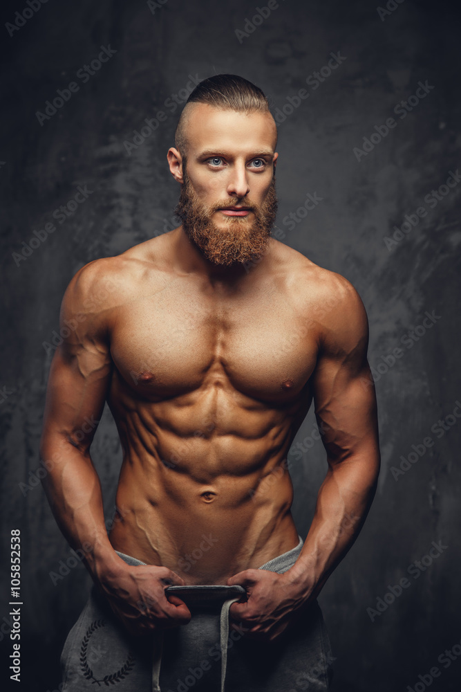 Shirtless muscular man with beard.