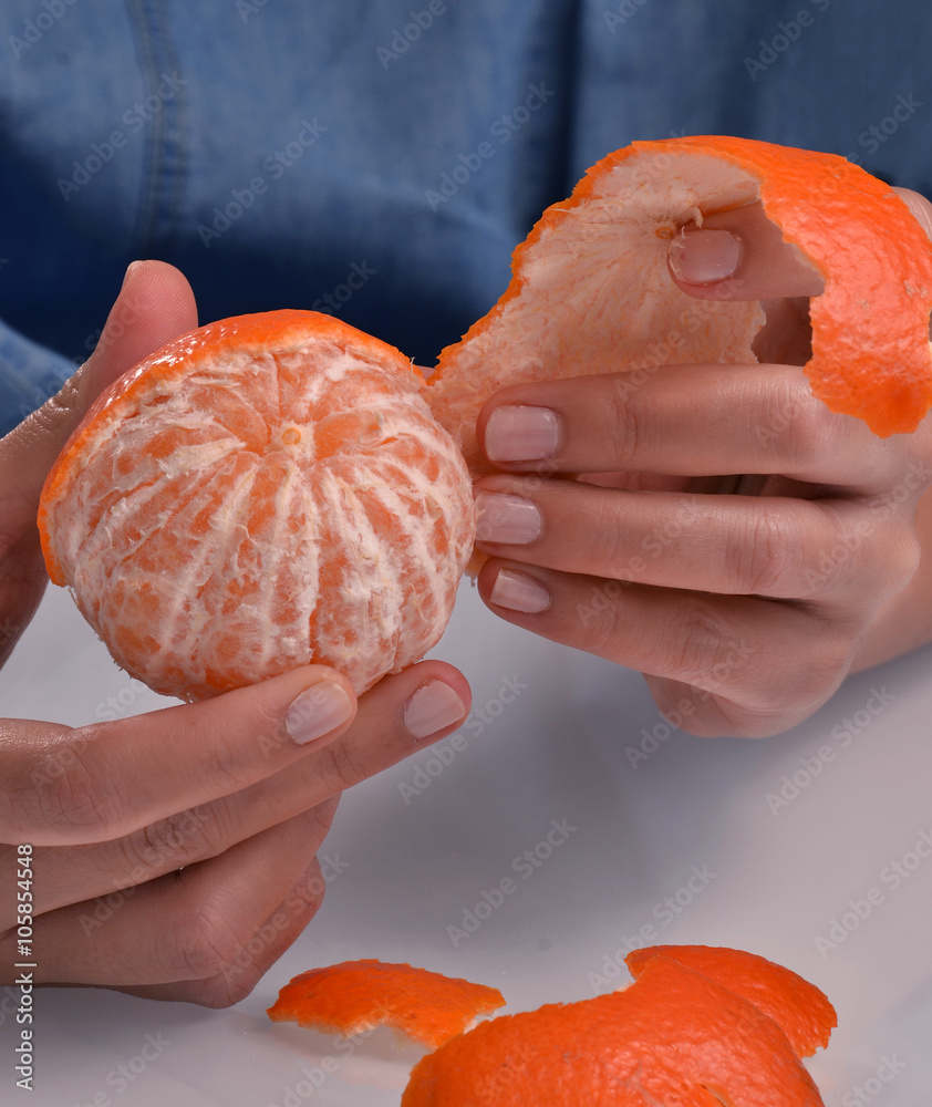 Pelando una mandarina, quitando concha a una mandarina. Stock