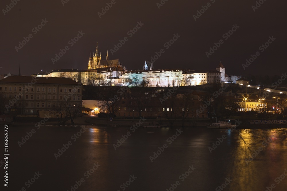 Night panoramatic landscape or citiline Picture of the Prague castle in the capitol of Czech Republic Prague. On the picure are Vltava river, small town quater, gardens and Saint Vitus cathedral.