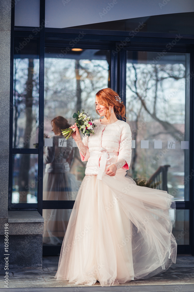 Happy bride on the background of modern urban glass building