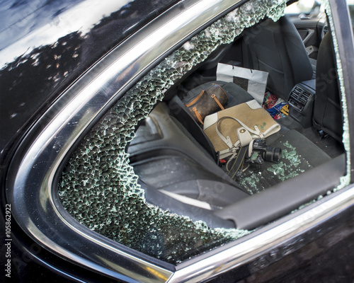 Smashed car window being used to rob a camera and handbag