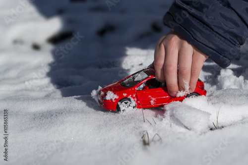 малыш катает машинку в снегу photo