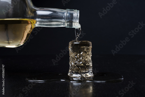 alcohol from bottle to glass spilling on table 