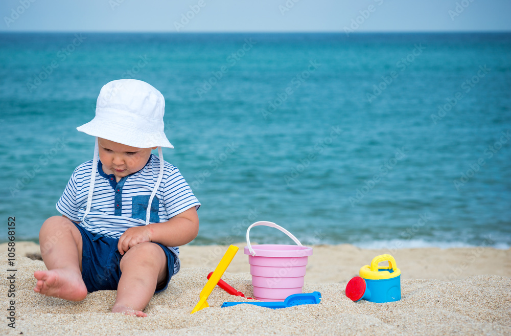 Cute baby boy playing with beach toys Cute baby boy playing with beach toys