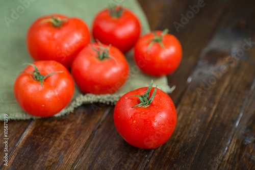 juicy and beautiful tomatoes on wooden rustic background