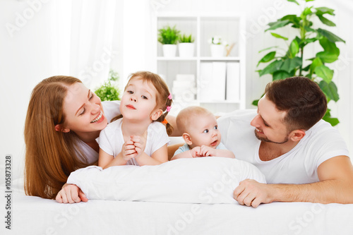 happy family at home in the bed