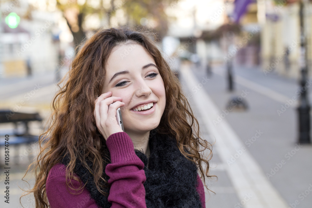 young woman talking on phone on city walking street in autumn young woman talking on phone on city walking street in autumn