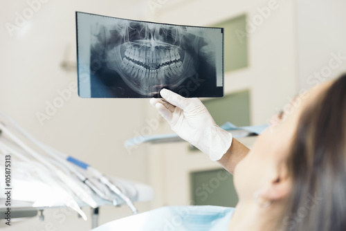 Foto Doctor talking with her patient and teaching a radiograph.