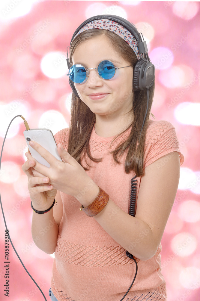 Naklejka premium preteen girl listening to music with his smartphone, bokeh backg