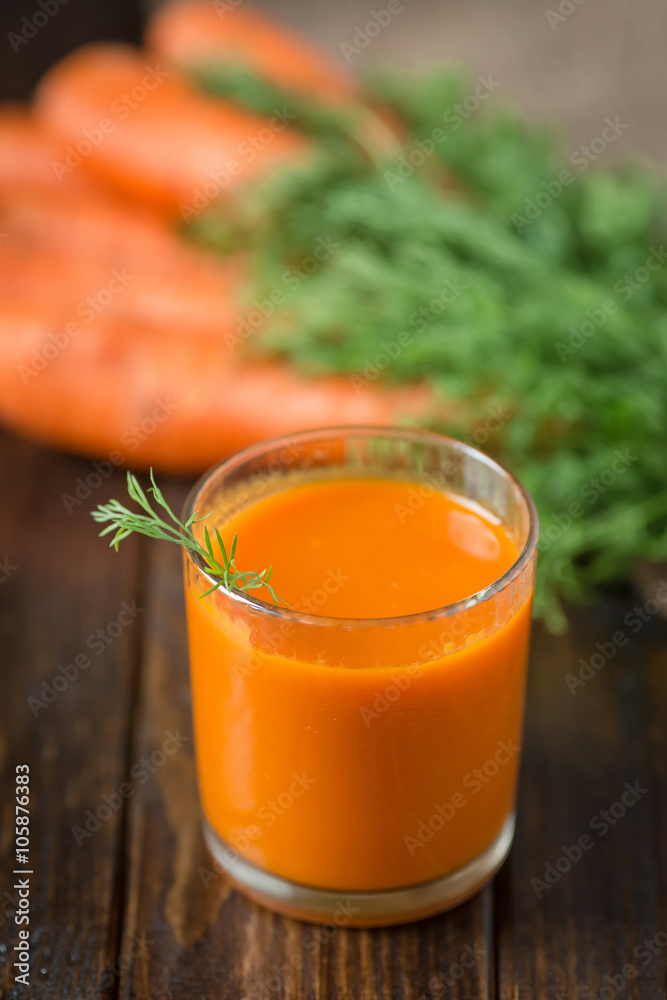 Carrot juice and fresh carrot on a wooden background Carrot juice and fresh carrot on a wooden background