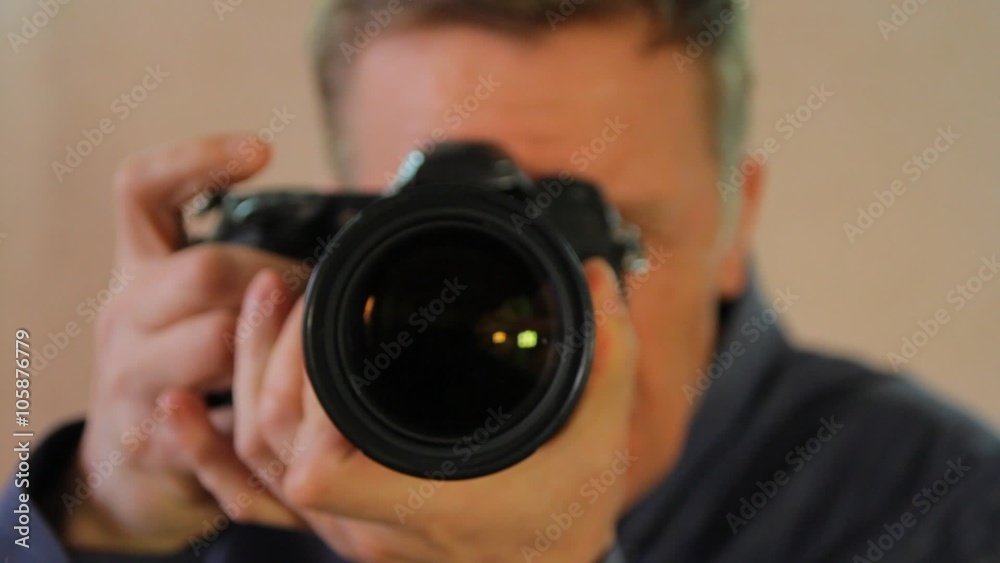 photographer with camera in hand looking through the camera lens photographer with camera in hand looking through the camera lens
