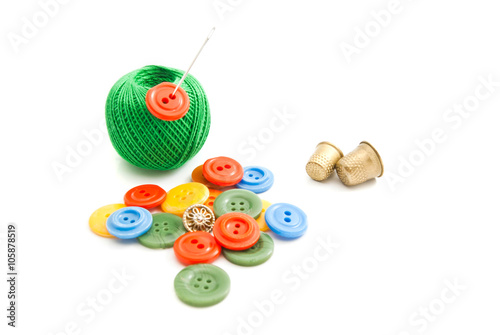 needle, buttons, thimbles and green thread