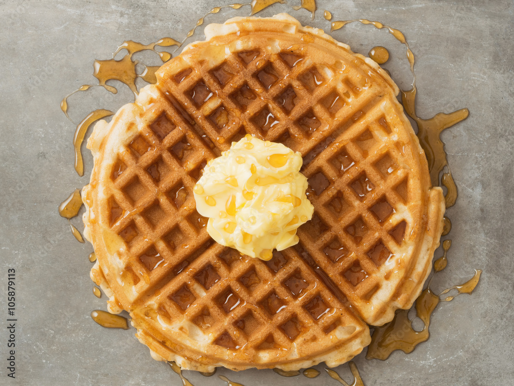 rustic traditional waffle with butter and maple syrup